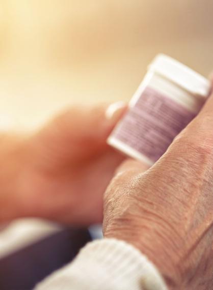 Bilde av en eldre sine hender som holder en pilleboks